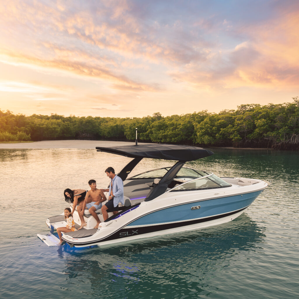 2023 SLX 260 SLX260 lifestyle starboard stern family swim platform step underwater accent lighting sunset 00043 select